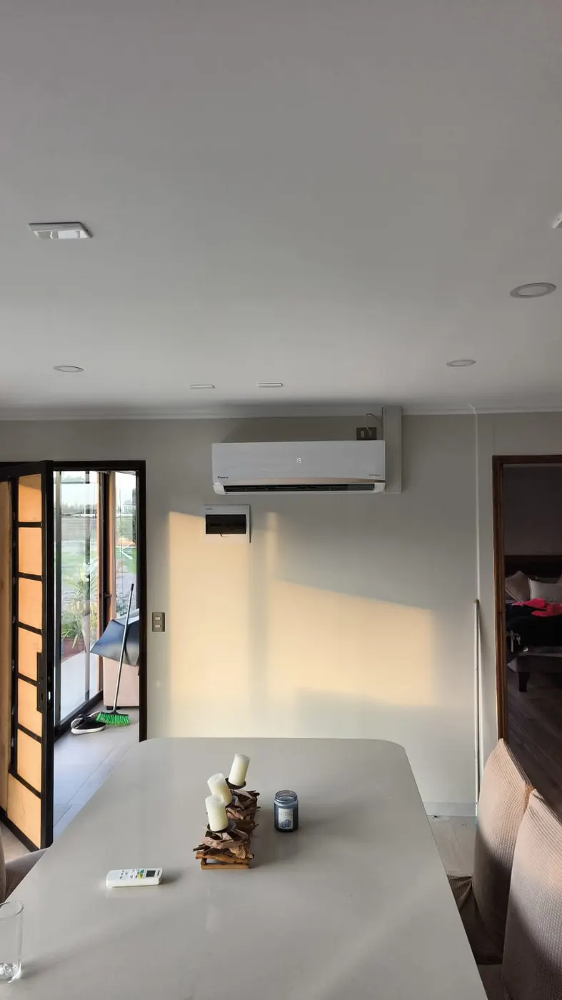 Equipo Daikin instalado en el comedor de una casa, sobre la puerta que da al patio.