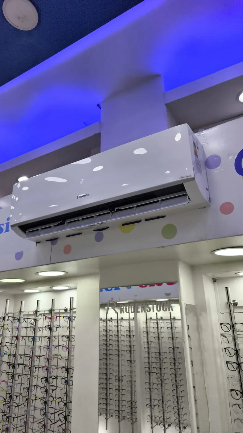 Equipo Hisense instalado sobre las vitrinas de lentes de una óptica.